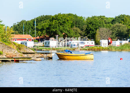 Una aperta giallo motonave attraccata ad una banchina con campeggio in background. Ubicazione Karlskrona, Svezia. Foto Stock