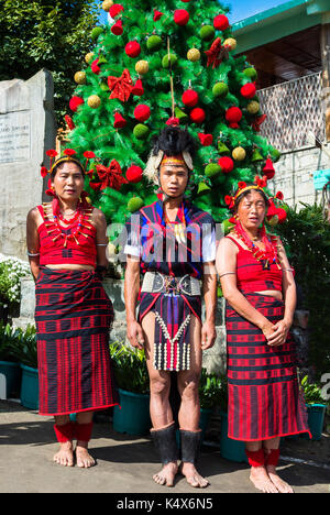 Naga gruppo tribale artisti interpreti o esecutori in piedi in linea per accogliere i funzionari presso il Festival di Hornbill, Kohima, Nagaland, India Foto Stock