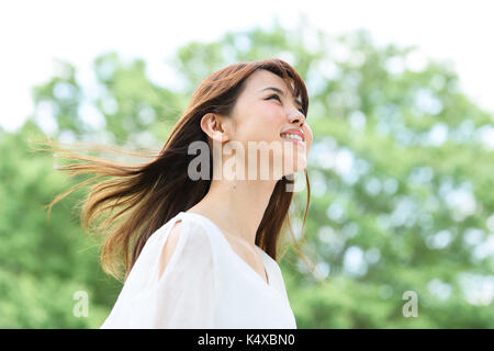 Giovane donna giapponese in un parco della città Foto Stock