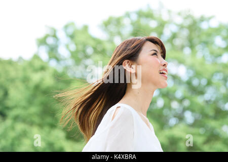 Giovane donna giapponese in un parco della città Foto Stock