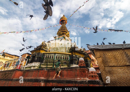 Un ragazzo si arrampica sulla kathesimbhu shree gha stupa di Kathmandu, Nepal. Foto Stock