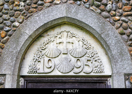 Muratura moderno con tre conchiglie simbolo di san Giacomo il maggiore presso la chiesa parrocchiale di San Giacomo a southrepps, Norfolk, Inghilterra, Regno Unito. Foto Stock