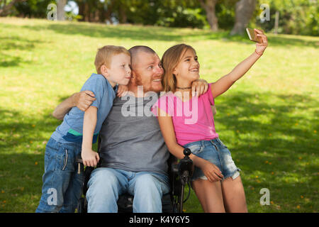 Padre disabili selfie facendo con i bambini. Foto Stock