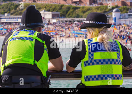 Cooperazione di polizia, poliziotto e poliziotta, a dovere sul molo di Bournemouth durante il Bournemouth Air Festival a Bournemouth Dorset Regno Unito nel mese di settembre Foto Stock