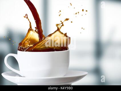Composito Digitale del caffè è versata nella tazza bianca contro sfocate ufficio grigio Foto Stock