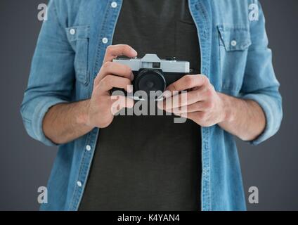 Composito Digitale dell uomo millenario metà sezione con fotocamera contro uno sfondo grigio Foto Stock