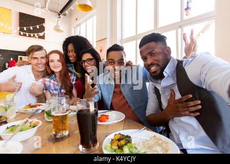 Happy amici prendendo selfie presso il ristorante o il bar Foto Stock