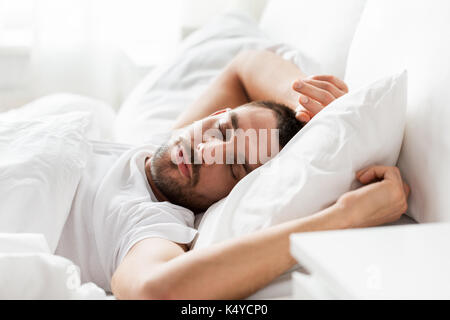 Uomo dorme nel letto di casa Foto Stock