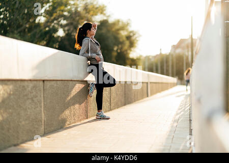 Bella donna di riposo in città dopo il jogging Foto Stock