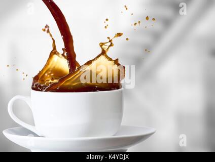 Composito Digitale del caffè è versata nella tazza bianca contro sfocate scale di grigio Foto Stock