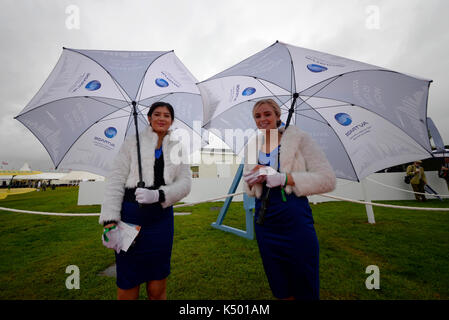 Femmine al Goodwood Revival 2017 nel periodo con ombrelli. Evento retrò in cattive condizioni atmosferiche Foto Stock