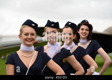 Femmine al Goodwood Revival 2017 in stile hostess d'epoca. Evento retrò in cattive condizioni atmosferiche Foto Stock