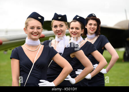 Femmine al Goodwood Revival 2017 in stile hostess d'epoca. Evento retrò in cattive condizioni atmosferiche Foto Stock