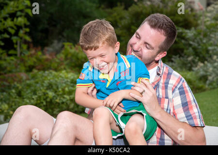 Padre solletico suo figlio Foto Stock