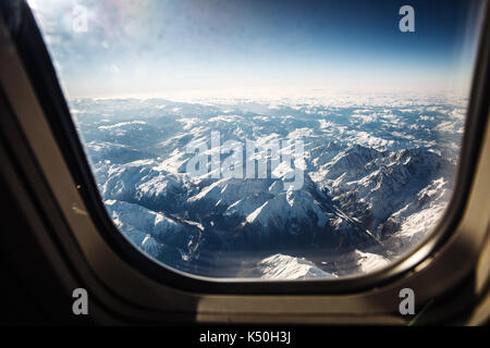 Vista mozzafiato delle alpi montagne dalla finestra di aeroplano Foto Stock