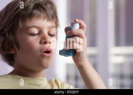 Boy utilizzando l'asma inalatore per trattare malattie infiammatorie, dispnea, tosse e di tenuta al torace e mancanza di respiro. allergia al concetto di trattamento. selet Foto Stock