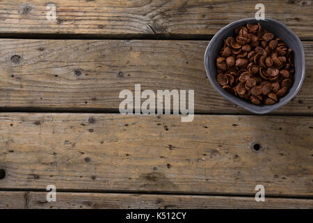 Cornflakes al cioccolato in tazza sul tavolo di legno Foto Stock