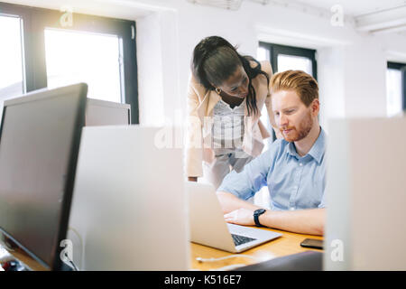 Supervisione di un collega durante il lavoro Foto Stock