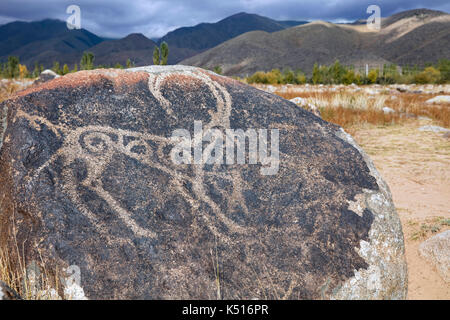 Antiche incisioni rupestri sul boulder raffigurante la caccia ibex a cholpon-ata lungo il lago Issyk Kul-in Kirghizistan Foto Stock