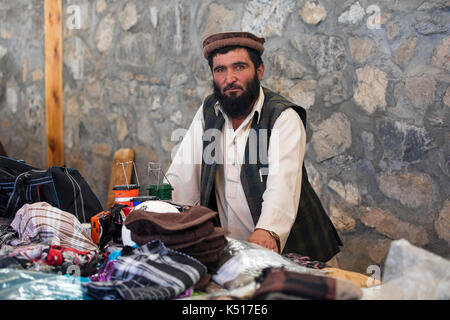 Trader afghano che vende merci al mercato di sabato / mercato di amicizia tagico-afghano a Khorugh, capitale di Gorno-Badakhshan in Tagikistan Foto Stock