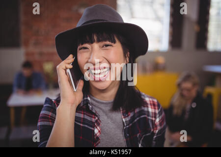 Ritratto di Allegro giovane donna ascolto di telefono cellulare presso la caffetteria Foto Stock