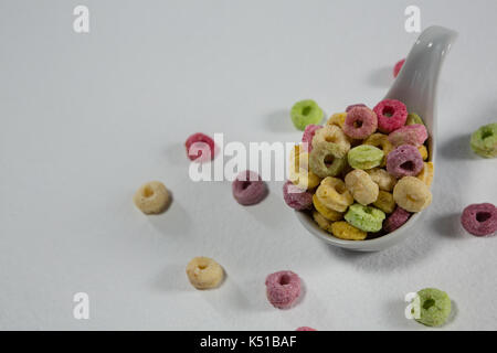 Froot loops in cucchiaio su sfondo bianco Foto Stock