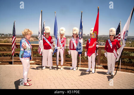 Indossare sfilata di uniformi, portando bandiere che commemora i servizi armati nonché la bandiera statunitense e diretto da un contemporaneo, senior donne si riuniscono per un quarto di luglio cerimonia in un Newport Beach, CA, Parco. Le donne sono membri del "alti america' organizzazione. Foto Stock