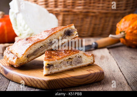 Fette di cavolo e funghi con torta di formaggio sulla tavola in legno rustico, comfort sano cibo vegetariano Foto Stock