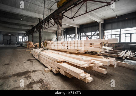 Stack di travi di legno in fabbrica. una pila di nuove barre lavorate nella produzione hall Foto Stock