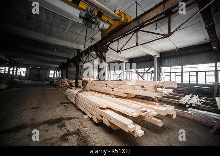 Stack di travi di legno in fabbrica. una pila di nuove barre lavorate nella produzione hall. Un altro punto di vista Foto Stock