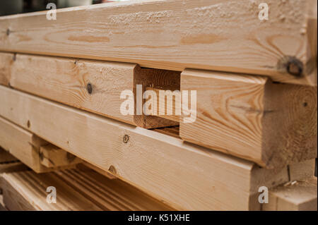 Stack di travi di legno in fabbrica. una pila di nuove barre lavorate nella produzione hall. closeup Foto Stock