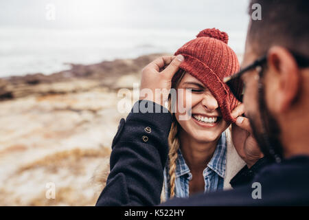 Close up ritratto di sorridente coppia giovane avendo divertimento all'aperto. L uomo e la donna che si diverte su una giornata invernale in spiaggia. Foto Stock