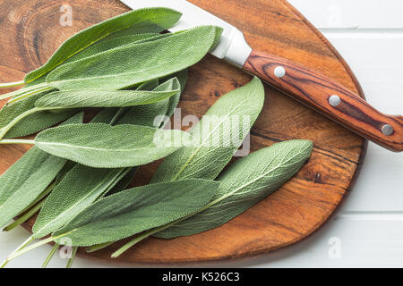 Salvia officinalis foglie di salvia sul tagliere di legno. Foto Stock