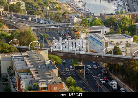 Mattina ora di punta del traffico su Sydney autostrada M1 a Woolloomooloo Australia Sydney ferrovia binari del treno attraversare l'autostrada Foto Stock