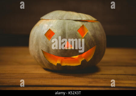 Elevato angolo di vista illuminato jack o lantern sul tavolo durante il periodo di Halloween Foto Stock