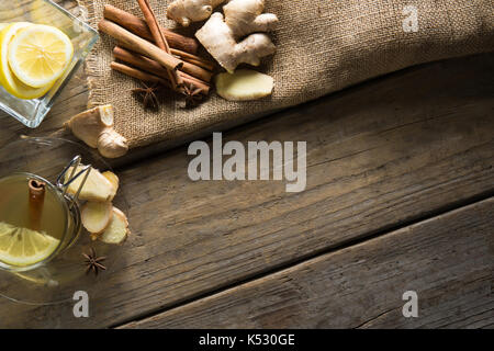 Angolo di alta vista di tè allo zenzero con limoni e cinnamons sul tavolo di legno Foto Stock