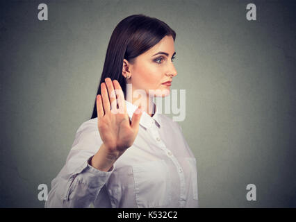 Closeup ritratto arrabbiato Donna che parla a mano gesto con il palmo verso l'esterno isolato sul muro grigio Sfondo. negativo emozione umana espressione faccia fe Foto Stock