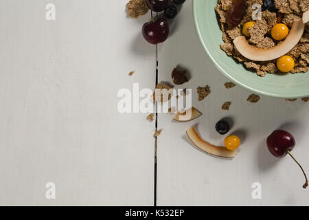 Ciotola di fiocchi di frumento con mirtillo e golden berry su tavola Foto Stock