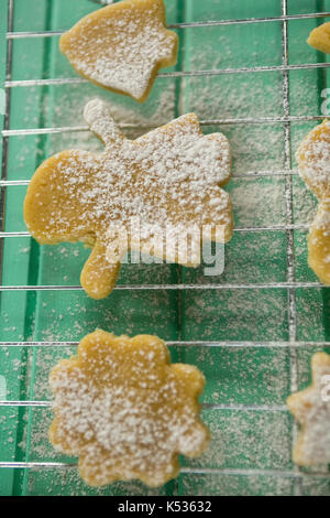 Vista aerea di zucchero in polvere su i cookie in raffreddamento per rack a tavola Foto Stock