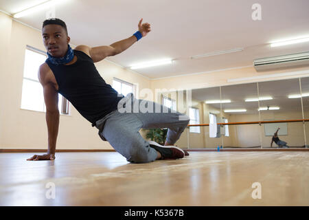 Ballerino maschio ripassando su pavimento in legno duro a studio Foto Stock