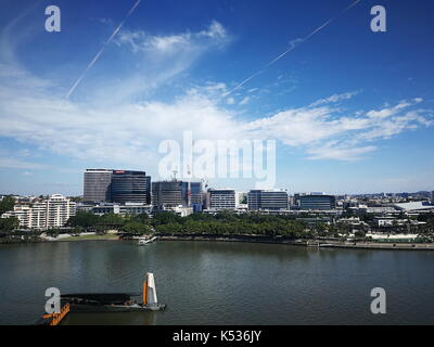 Vista della città di Brisbane attraverso il fiume con Griffith University campus in distanza e QUT Giardini punto terminale dei traghetti in primo piano Foto Stock