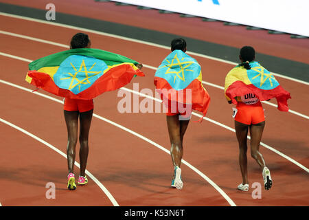 Dera DIDA (Etiopia), Almaz L'Ayana (Etiopia), Tirunesh DIBABA (Etiopia) drappeggiati in la bandiera etiope dopo la donna 10000m finale al 2017, IAAF Campionati del Mondo, Queen Elizabeth Olympic Park, Stratford, Londra, Regno Unito. Foto Stock