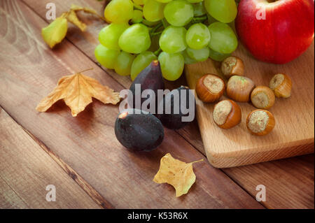 Composizione di autunno, raccolto, frutta - funghi, mele prugne foglie autunno umore. concetto di autunno, raccolta delle scorte per l'inverno Foto Stock