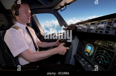 Vista laterale del giovane pilota maschio Battenti aereo dal cockpit Foto Stock