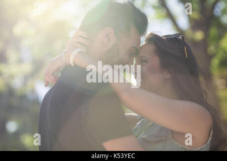 Ritratto di giovane coppia felice in amore poggiando su ogni altra testa in presenza di luce solare Foto Stock