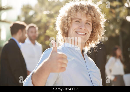 Ritratto di happy businessman che mostra il pollice in alto Foto Stock