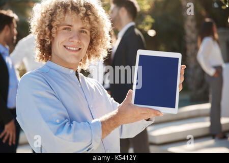 Ritratto di imprenditore sorridente mostra nuovissimo tablet Foto Stock