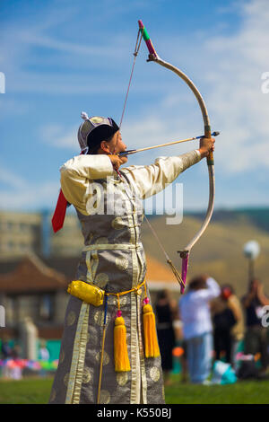 Ulaanbaatar, in Mongolia - giugno 11, 2007: un bellissimo vestito donna mongola archer puntando la sua freccia al tradizionale festival naadam femmina di tiro con l'arco Foto Stock