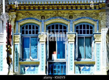 Singapore tradizionale negozio Casa esterno con sculture ornate, finestre ad arco e in legno di colore blu persiane a lamelle nella storica Joo Chiat area. Foto Stock