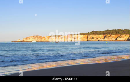 Il sole appena risorto illumina le scogliere e l'oceano blu a Praia do Vau Portimao Faro quartiere Algarve Portogallo Europa Foto Stock